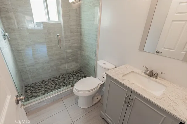 a bathroom with a granite countertop sink toilet and shower