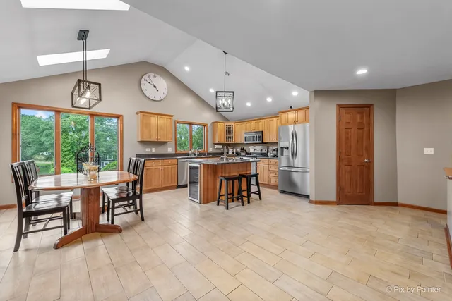 a kitchen with stainless steel appliances granite countertop a kitchen island a stove a table and chairs