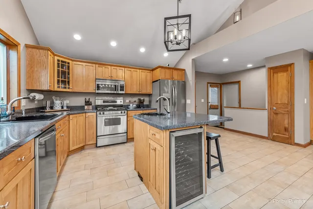 a kitchen with granite countertop a stove a sink a dining table and chairs