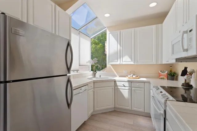 a kitchen with white cabinets and white appliances