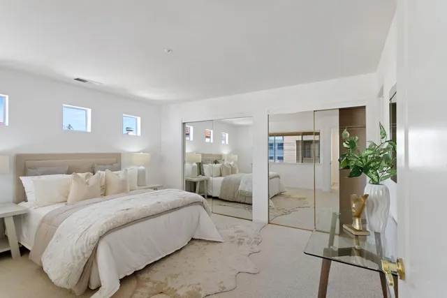 a bedroom with a bed and a potted plant