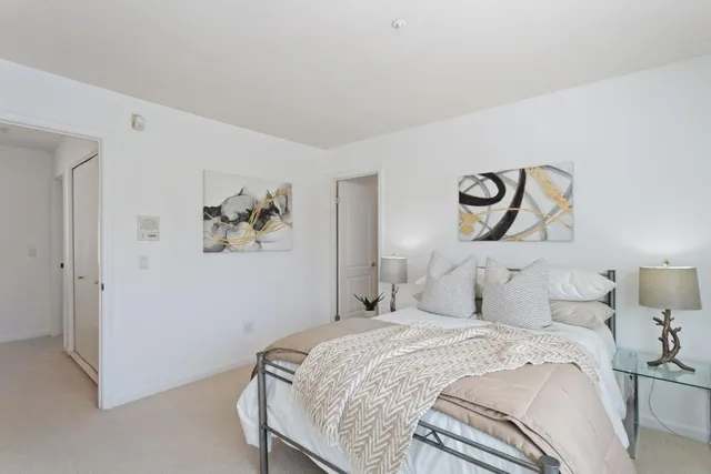 a bedroom with a bed and painting on the wall