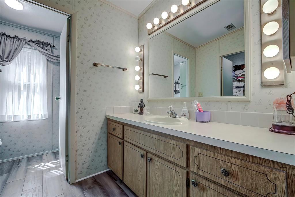 3307 Keye Drive Spring Hill, FL 34606 - Photo 24 of 29 a bathroom with a granite countertop sink a mirror and a shower