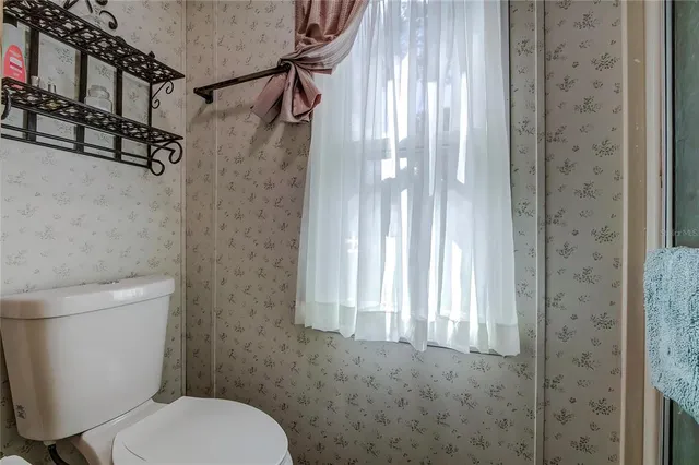 a white toilet sitting next to a shower curtain