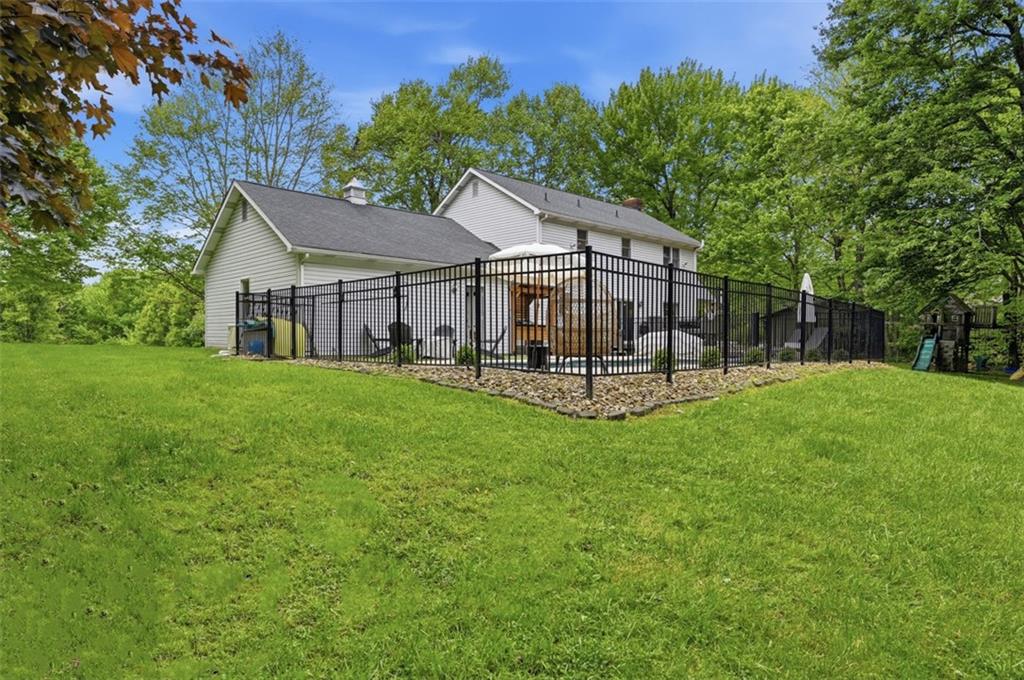 167 Wellington Road Aliquippa, PA 15001 - Photo 5 of 49 Back of house with fencing around the in-ground pool.
