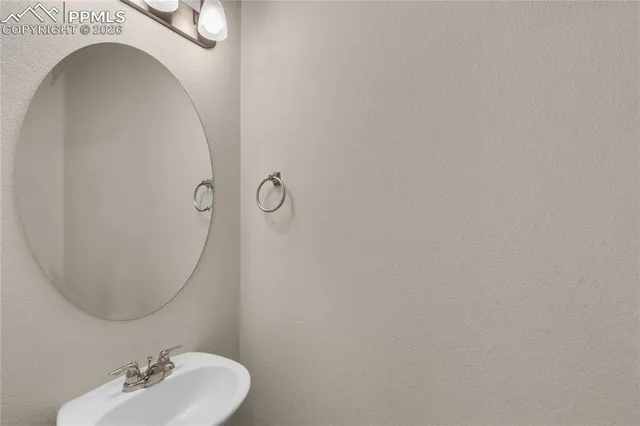 an empty room with chandelier fan and windows