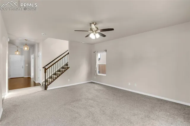 an empty room with a kitchen view and windows