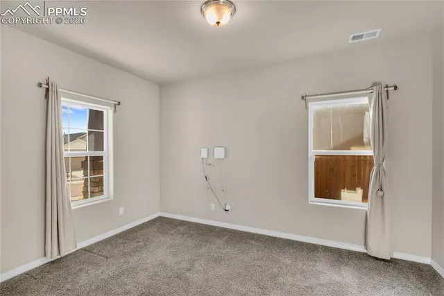 a view of a hallway with wooden floor and windows
