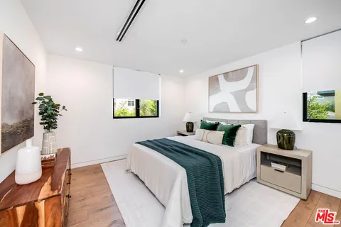 a bedroom with a bed and a potted plant