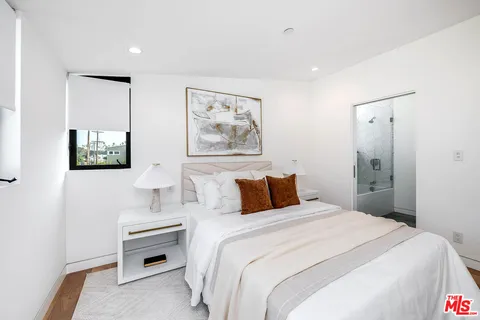 a bedroom with a bed and a painting on the wall