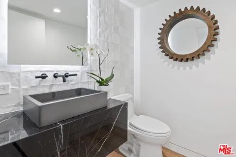 a bathroom with a sink a mirror and a toilet