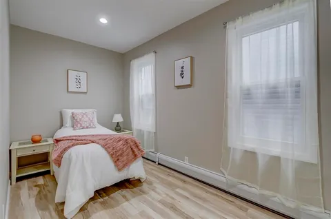 a bedroom with a bed and wooden floor