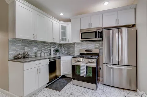 a kitchen with cabinets stainless steel appliances and a counter space