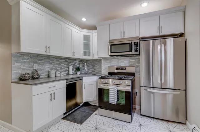 a kitchen with cabinets stainless steel appliances and a counter space