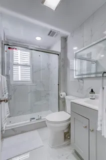 a bathroom with a sink a toilet and shower