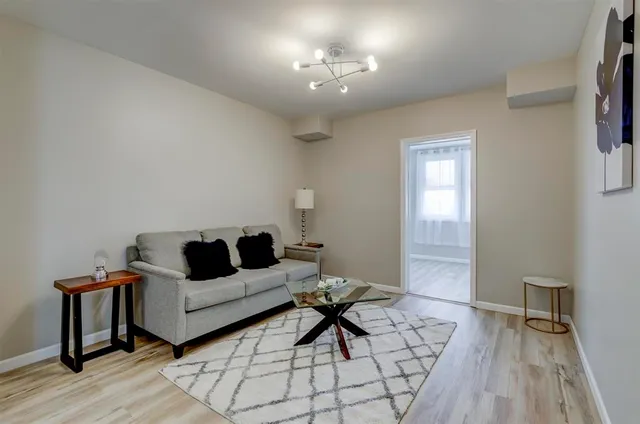 a living room with furniture and a wooden floor
