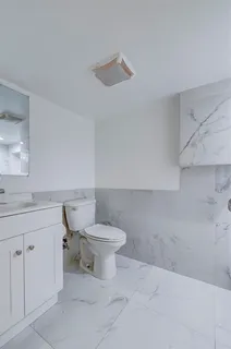 a white toilet sitting next to a bathroom sink