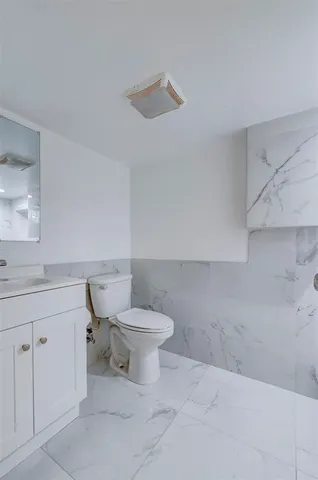 a white toilet sitting next to a bathroom sink