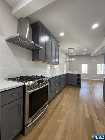 a kitchen with stainless steel appliances a sink cabinets and wooden floor
