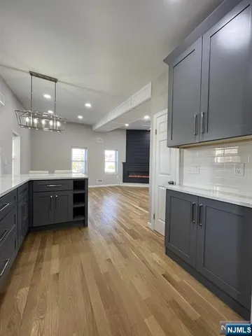 a large kitchen with kitchen island granite countertop a sink and a stove top oven