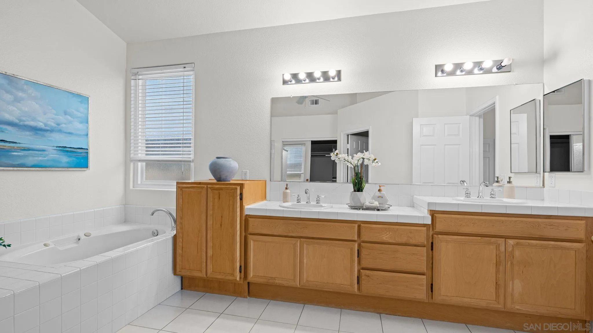 1783 Medinah Road San Marcos, CA 92069 - Photo 20 of 39 a bathroom with a double vanity sink a mirror a bathtub and window