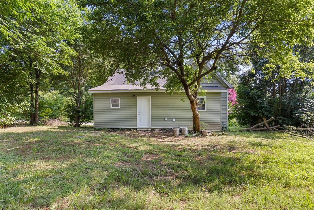 109 Farmer Street Anderson, SC 29621 - Photo 4 of 31 A quaint rear facade, embraced by verdant trees, offers a private outdoor retreat.