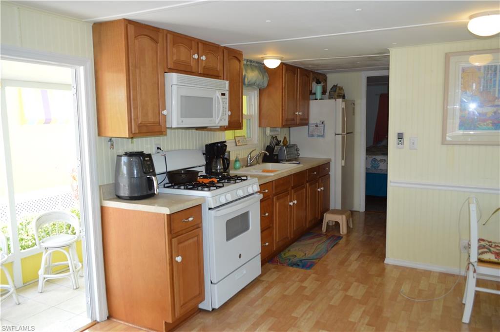 414 Papaya Street, Unit C Goodland, FL 34140 - Photo 6 of 13 a kitchen with stainless steel appliances granite countertop a stove a refrigerator and a sink