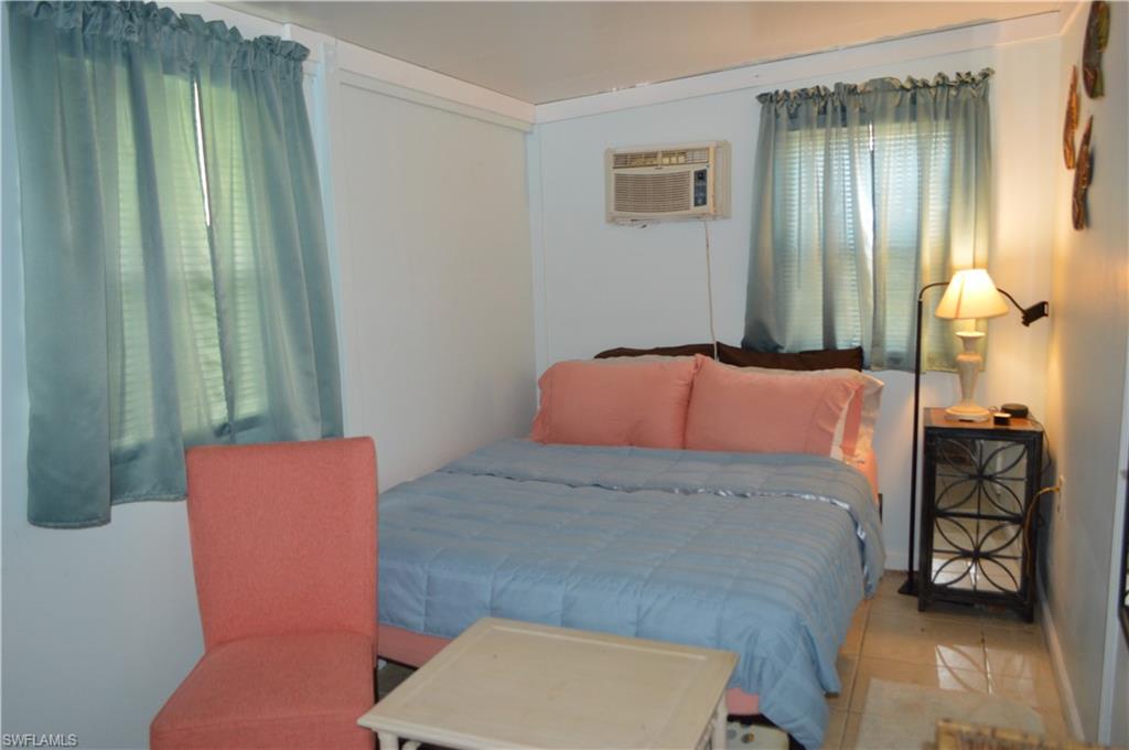 414 Papaya Street, Unit C Goodland, FL 34140 - Photo 9 of 13 a bedroom with a bed and a mirror