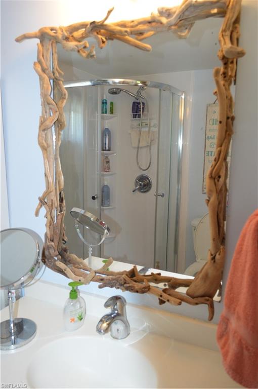 414 Papaya Street, Unit C Goodland, FL 34140 - Photo 10 of 13 a bathroom with a granite countertop sink a mirror and shower