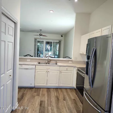 a kitchen with white cabinets and stainless steel appliances