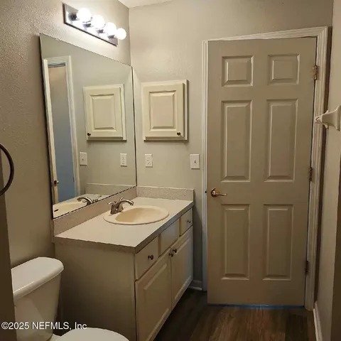 a bathroom with a granite countertop sink toilet and mirror