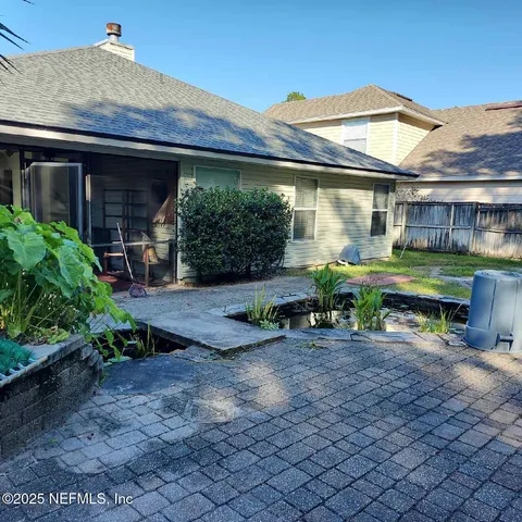 a view of a house with backyard and sitting area