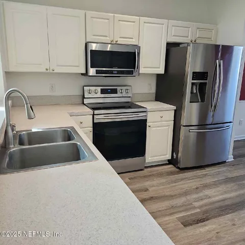 a kitchen with a refrigerator stove and microwave
