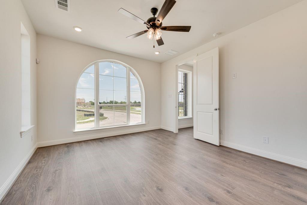 248 Golden Run Drive Fate, TX 75189 - Photo 12 of 34 a view of an empty room with a window and wooden floor
