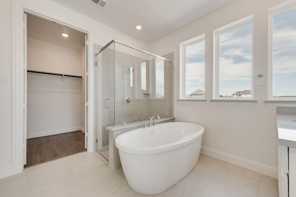 248 Golden Run Drive Fate, TX 75189 - Photo 13 of 34 a white bath tub sitting in a bathroom next to a window