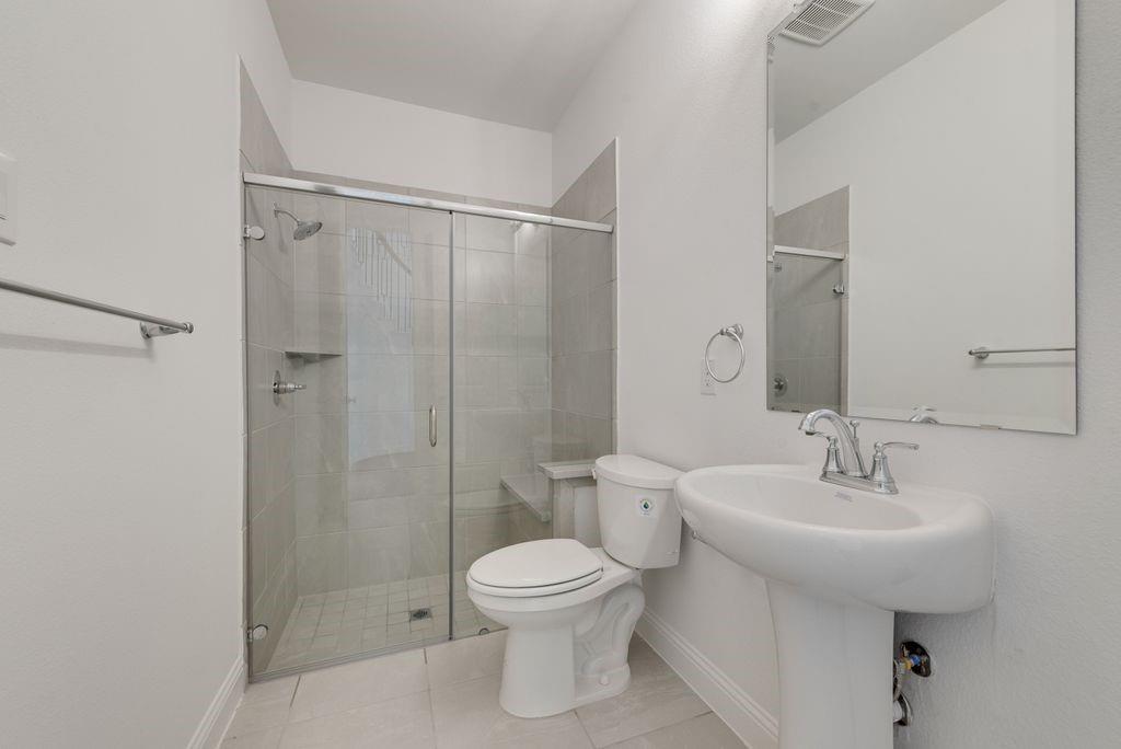 248 Golden Run Drive Fate, TX 75189 - Photo 16 of 34 a bathroom with a toilet sink and shower