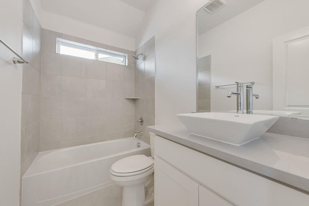 248 Golden Run Drive Fate, TX 75189 - Photo 20 of 34 a bathroom with a sink a toilet a mirror and shower