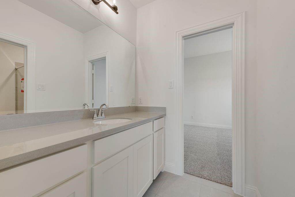 248 Golden Run Drive Fate, TX 75189 - Photo 22 of 34 a bathroom with a granite countertop sink and a mirror