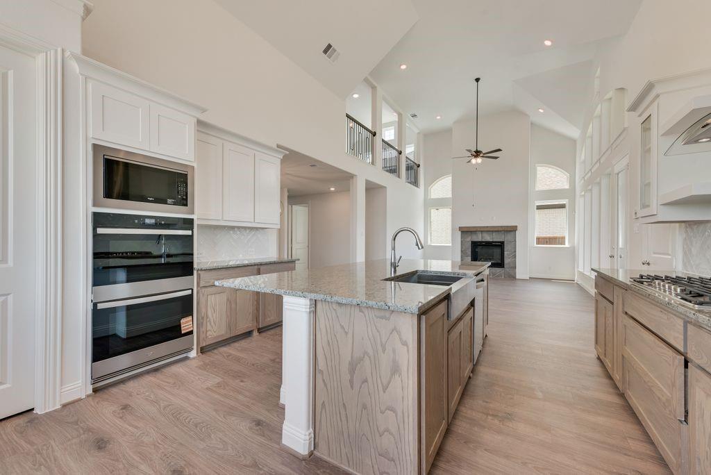 248 Golden Run Drive Fate, TX 75189 - Photo 8 of 34 a kitchen with stainless steel appliances granite countertop a kitchen island hardwood floor sink and stove
