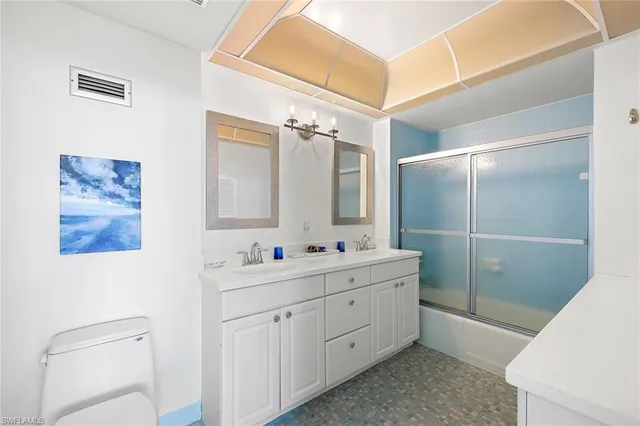 a bathroom with a double vanity sink mirror and toilet