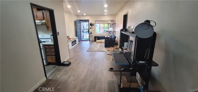 a view of a hallway with wooden floor and furniture