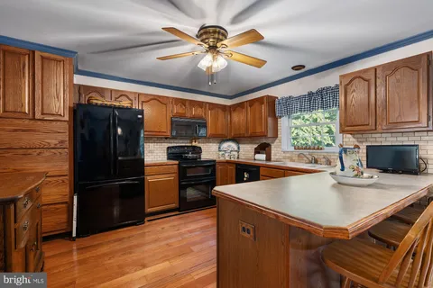 a kitchen with a refrigerator a sink dishwasher and a stove with wooden floor