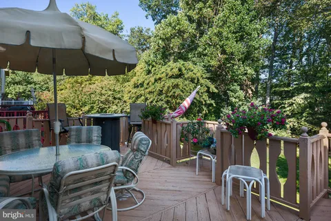 a patio with wooden floor a yard a table and chairs