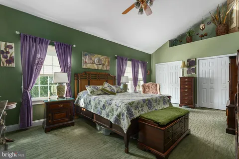 a bedroom with a bed a dresser next to a window