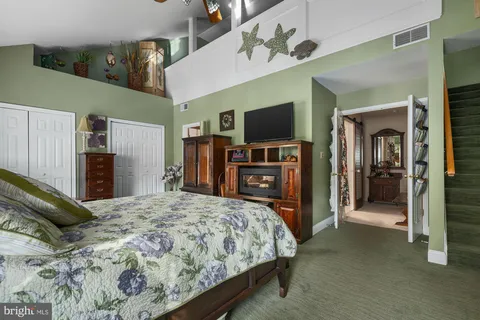 a bedroom with a bed and a flat tv screen on wall