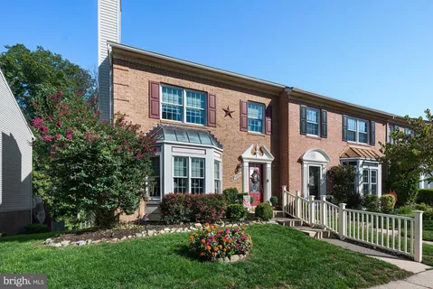 a front view of a house with a garden and plants