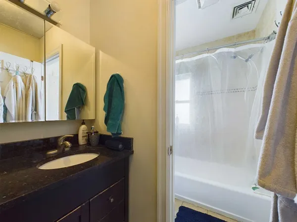 a bathroom with a granite countertop sink and a mirror