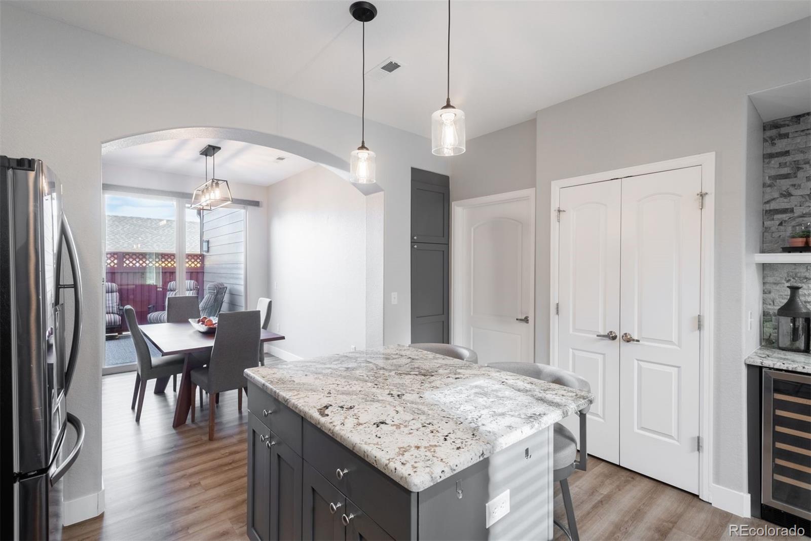 8555 Gold Peak Drive, Unit B Highlands Ranch, CO 80130 - Photo 12 of 38 a kitchen with a table chairs refrigerator and wooden floor