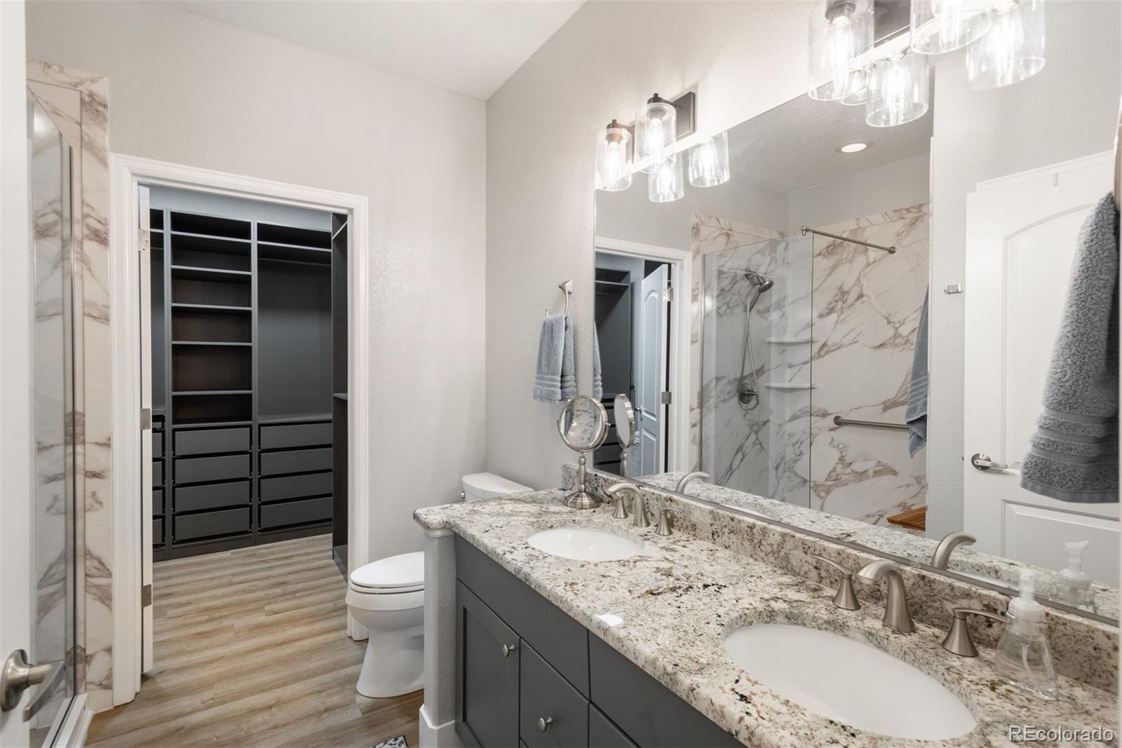8555 Gold Peak Drive, Unit B Highlands Ranch, CO 80130 - Photo 15 of 38 a bathroom with a granite countertop sink toilet and shower