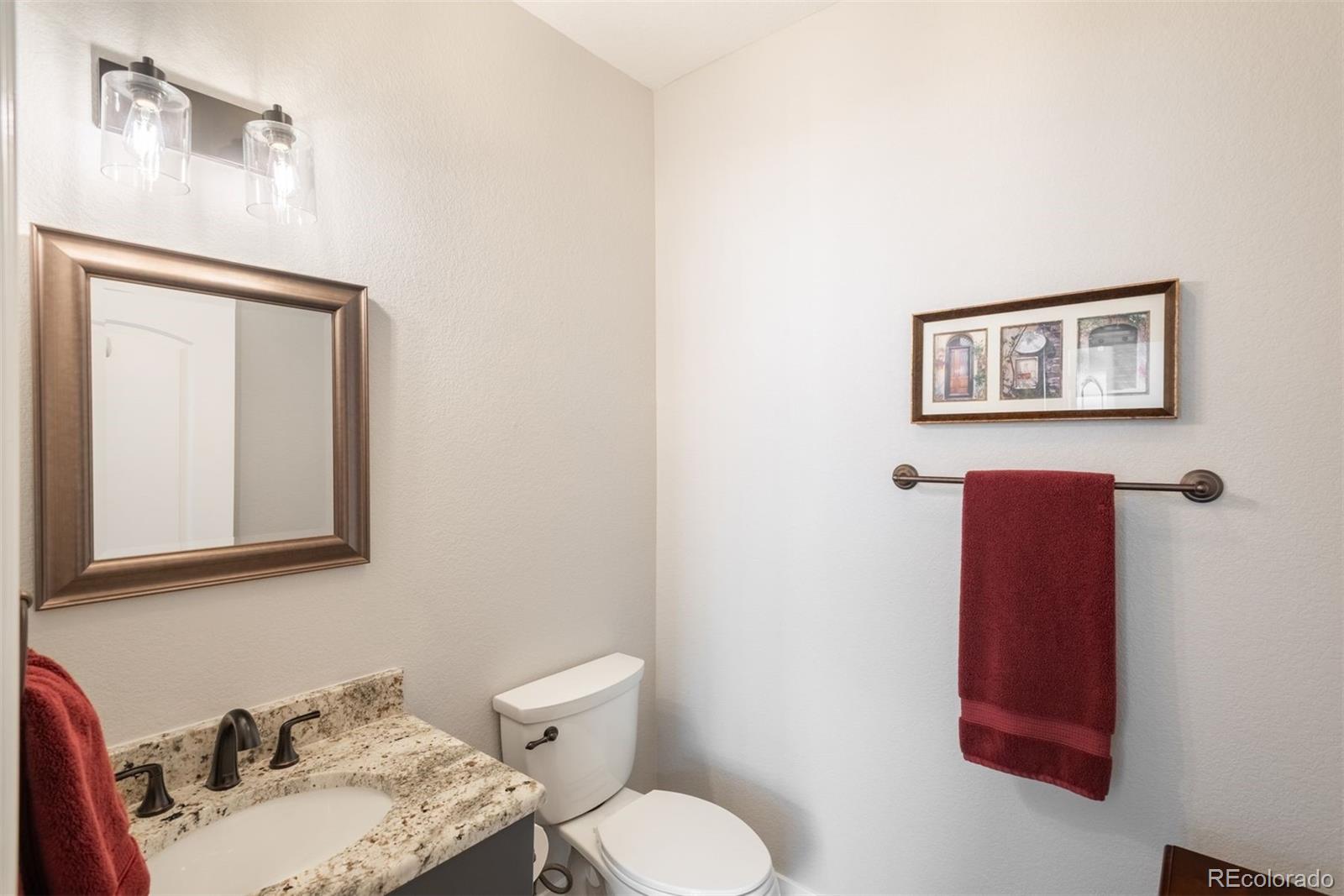8555 Gold Peak Drive, Unit B Highlands Ranch, CO 80130 - Photo 17 of 38 a bathroom with a toilet sink vanity and mirror